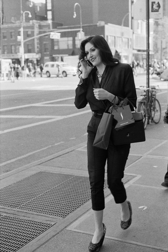 Woman on 14th St. walking and talking to phone, New York