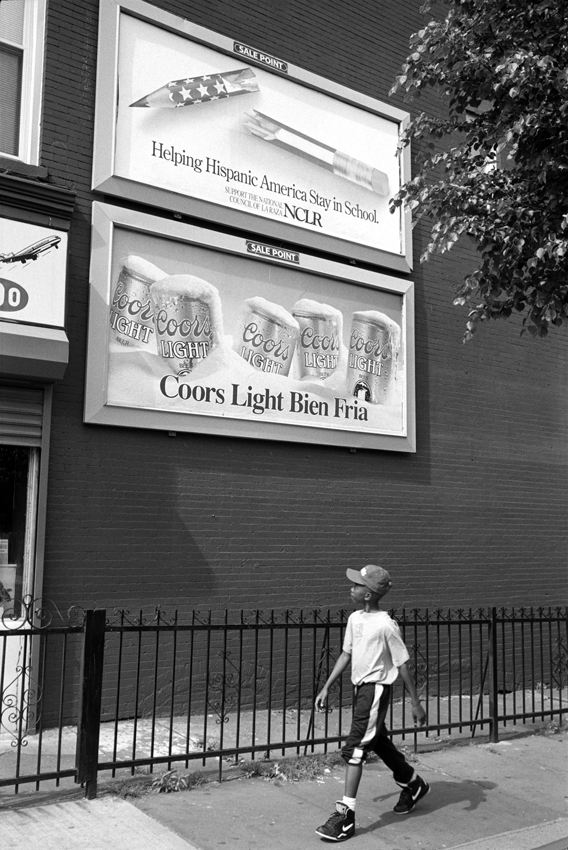 Young man walking by advertising, Brooklyn